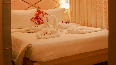 Bedroom with upholstered headboard and warm lighting at Hotel Mumbai House Digha, Airoli.