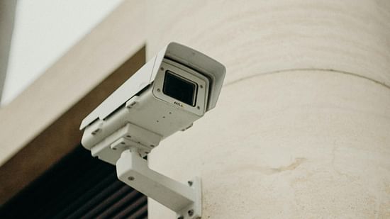 A close-up of a security camera mounted on a wall, ensuring safety and surveillance around the property