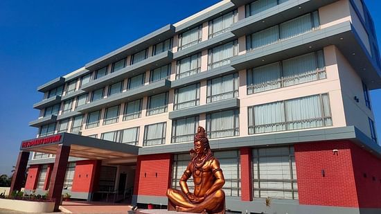 An image of the enormous hotel with lord shiva statue at the front 