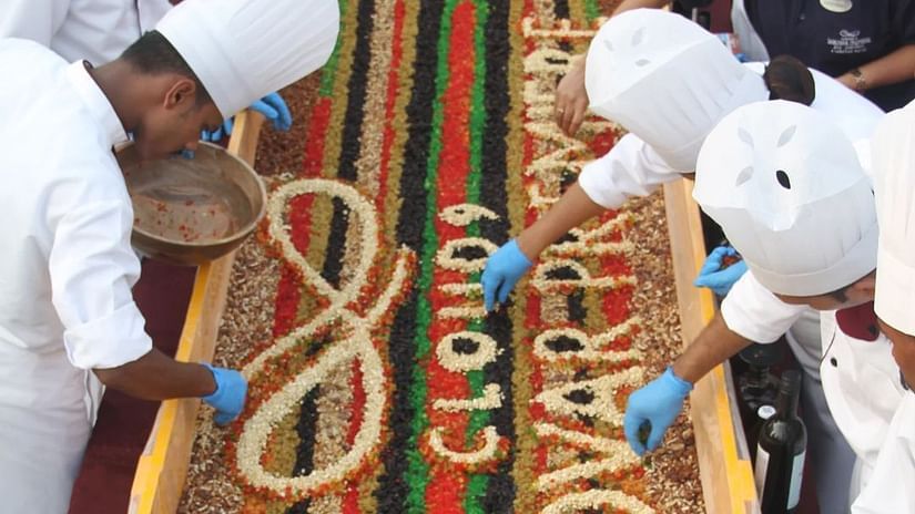 An image of chefs and many other people decorating cake with dry fruits at Cloud9 Sarovar Premiere, Palolem Goa