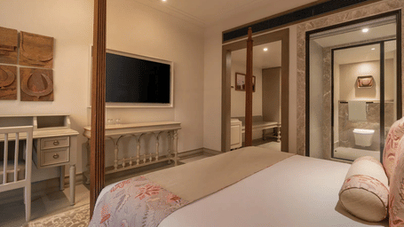 The Classic Room at The Evren, Vagator, featuring a double bed along with a wall-mounted television in front of it.