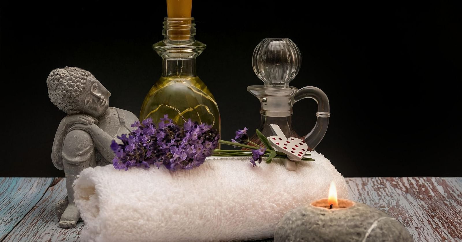 Spa items like oils, lavender, candles, and a towel arranged for a luxurious experience.