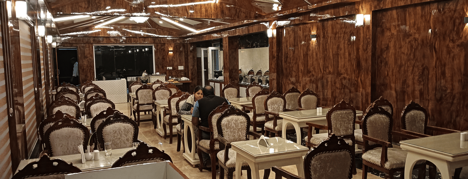 A well-lit multi-cuisine restaurant with wooden interiors and cosy dining setup for guests - Benzz Park, Kodaikanal