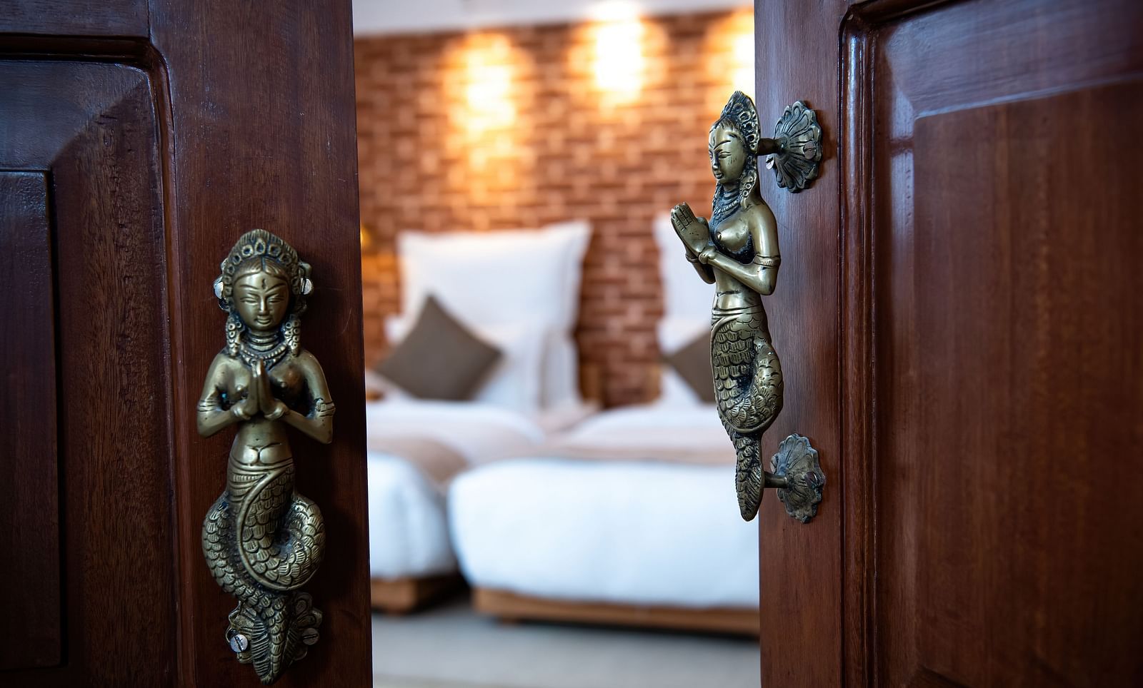 A partially open door with brass handles leads into a room at The Nanee.