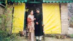 A couple posing for a picture in front of a room after their Kumaon Wedding - Ramgarh Bungalows, Nainital.