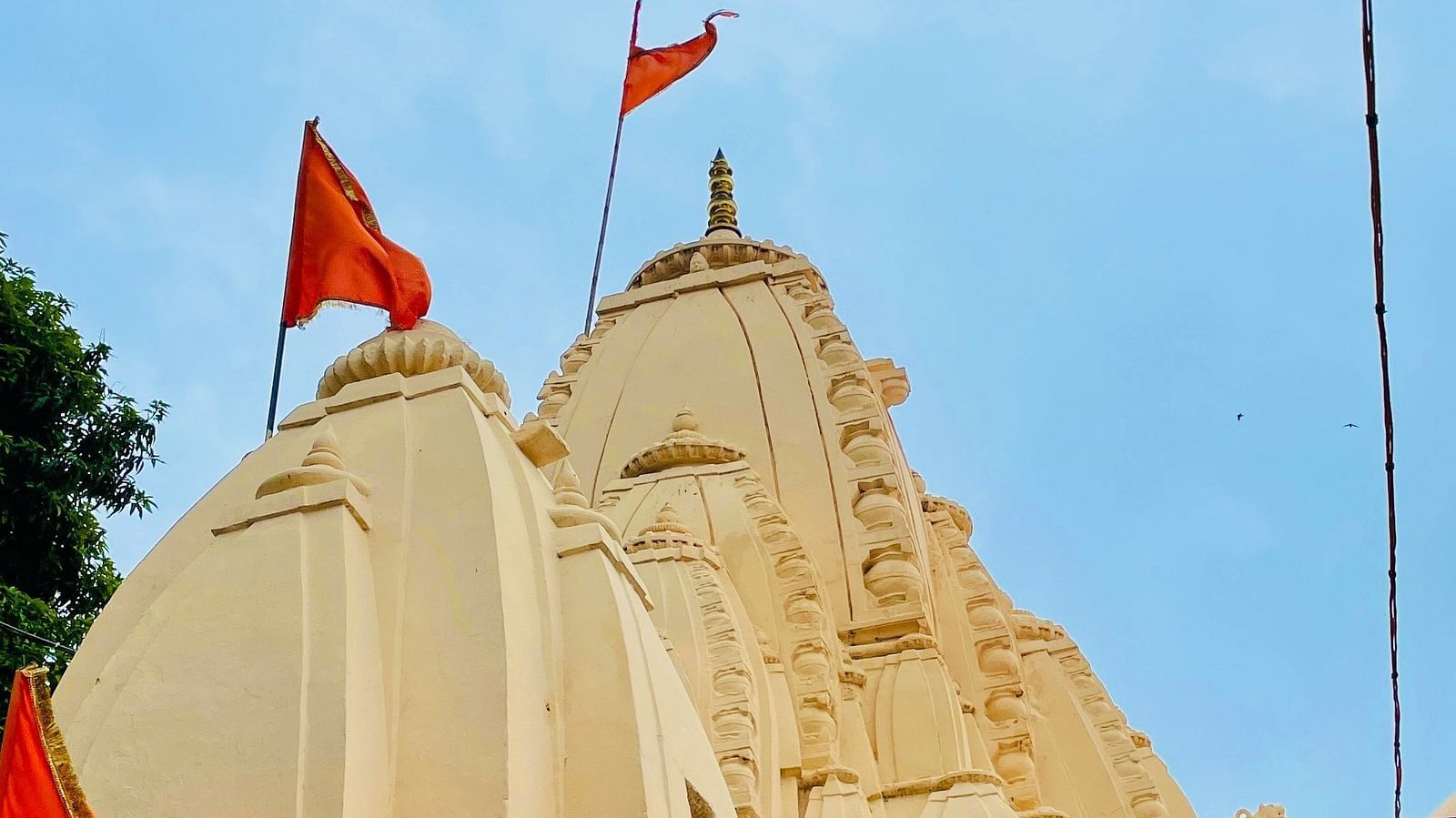 Exterior view of a temple with a red flag atop.