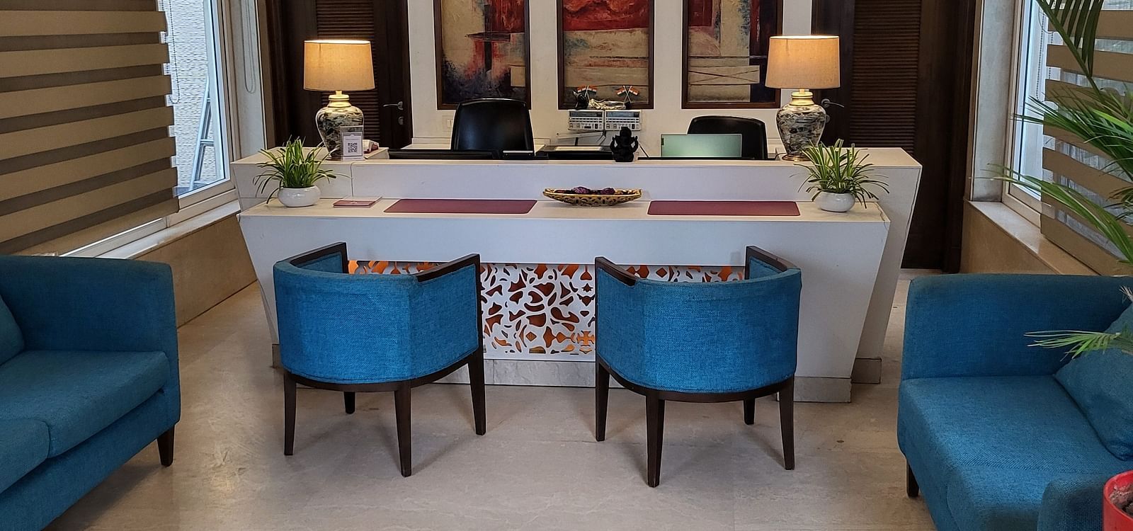 An image of a reception lobby featuring sofas, chairs, reception desk, and lights hanging from the ceiling - Inde Hotel Signature Tower Gurgaon
