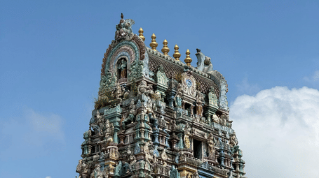 Majestic South Indian temple gopuram rising into a bright blue sky.