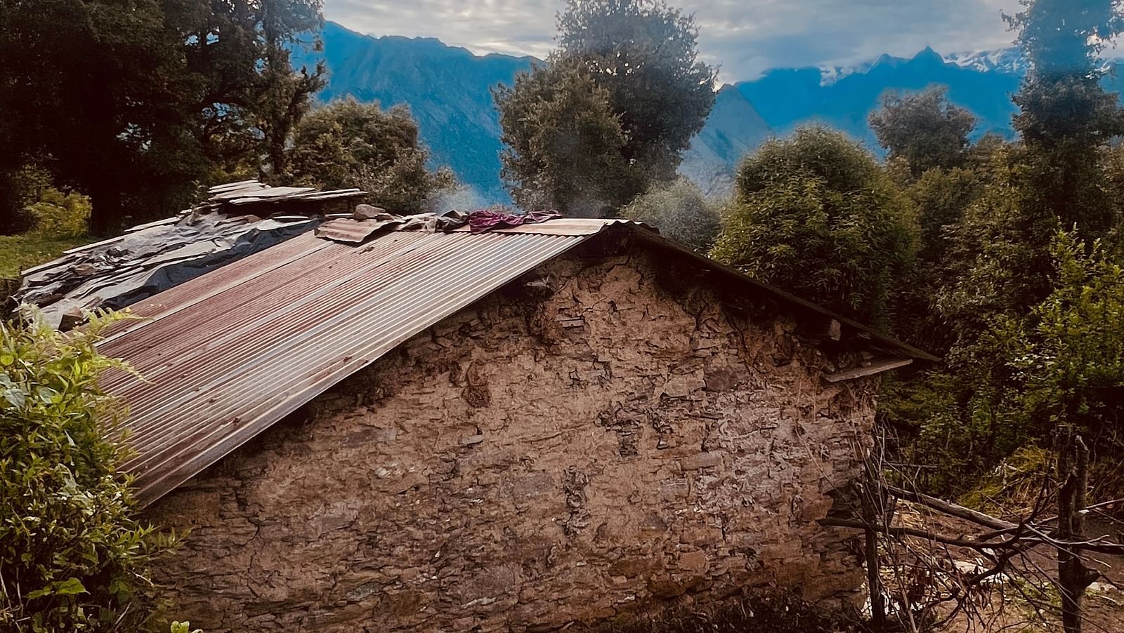 Image of stonewood house with scattered clouds in the background | Faraway Cottages, Auli