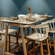 Restaurant interior featuring a striking blue wall, wooden bar-height table and stools at OJ Japanese Restaurant, Featherlite Evoma Hotel.