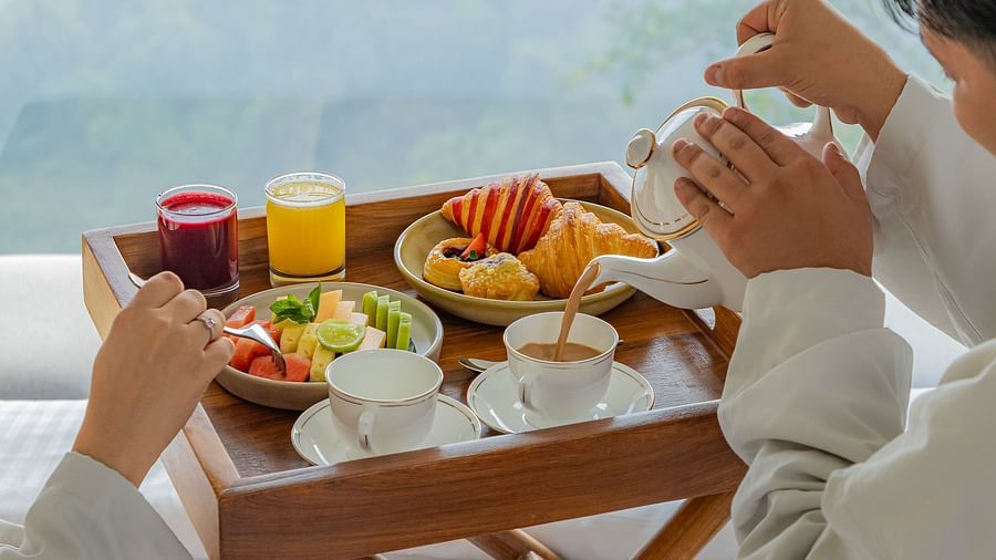 Couple enjoying a cosy in-room breakfast with a scenic valley view at The Dukes Retreat
