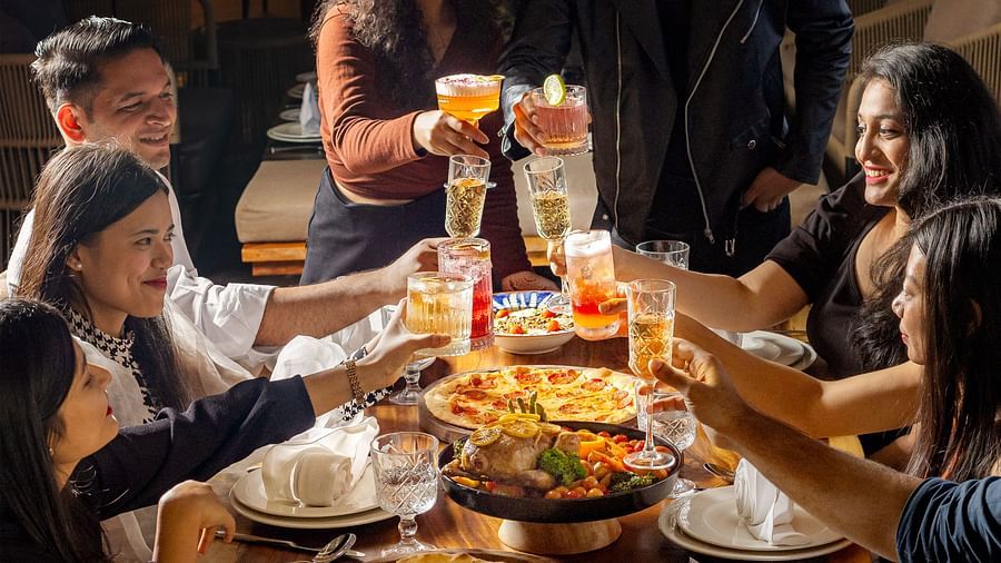 Group of friends celebrating with food and drinks at The Dukes Retreat’s vibrant dining space