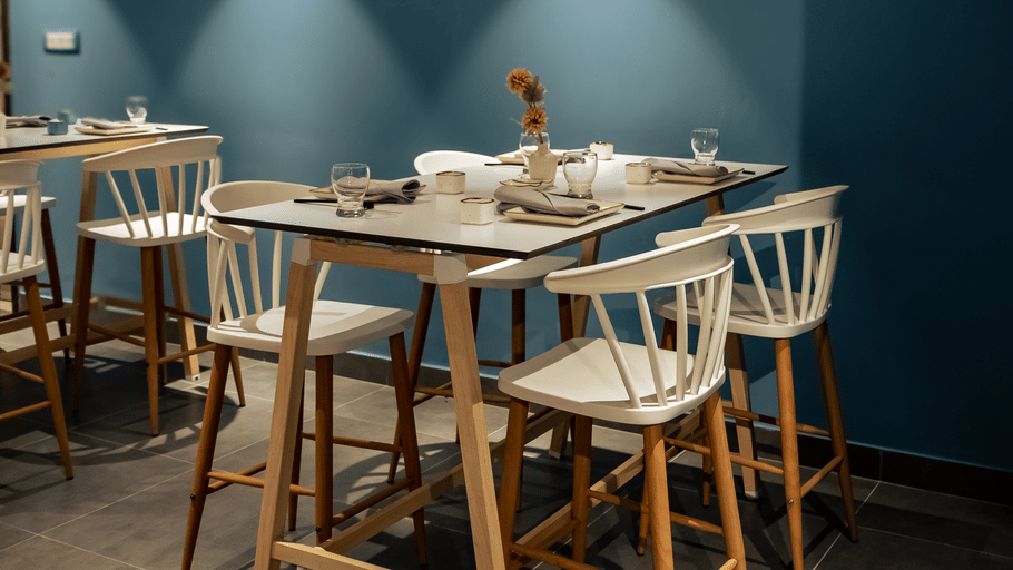 Restaurant interior featuring a striking blue wall, wooden bar-height table and stools at OJ Japanese Restaurant, Featherlite Evoma Hotel.