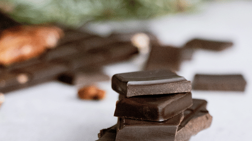 Many pieces of chocolates kept on top of each other on a white table.