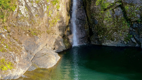 A long stream of waterfall falling from a tall cliff