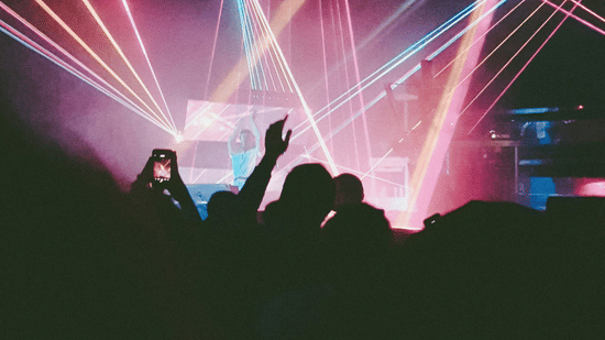 pexels-sebastiaan9977-337926Silhouettes of a crowd with their hands raised during a colourful pink laser light display.
