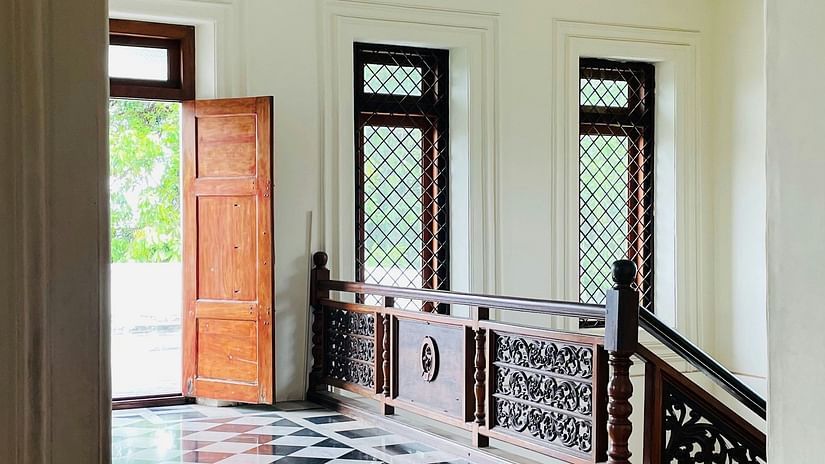 three doors and a staircase in view with black and white checked square tiled floor leading up to the doors.