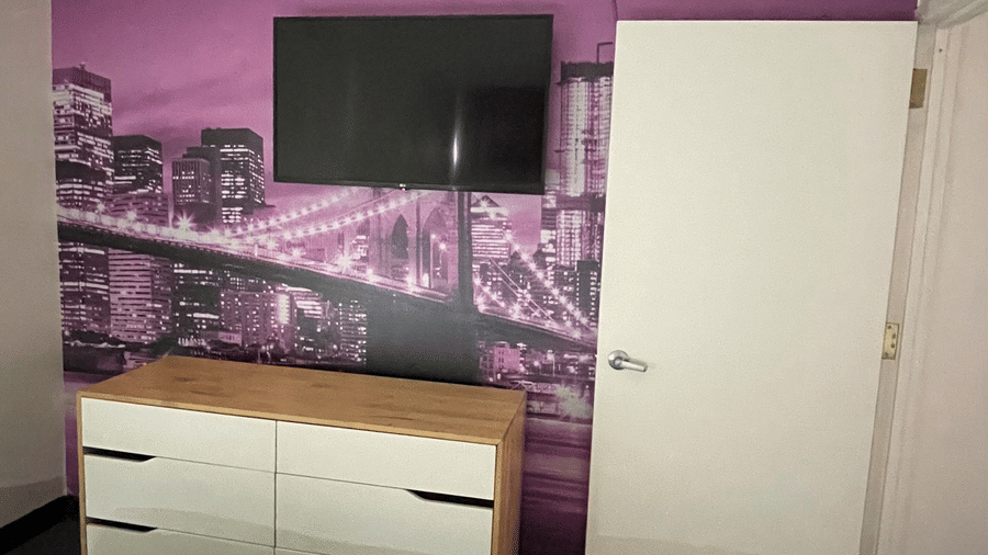 Guest room at Night Hotel Broadway featuring a bed, dresser, and wall art above the headboard.