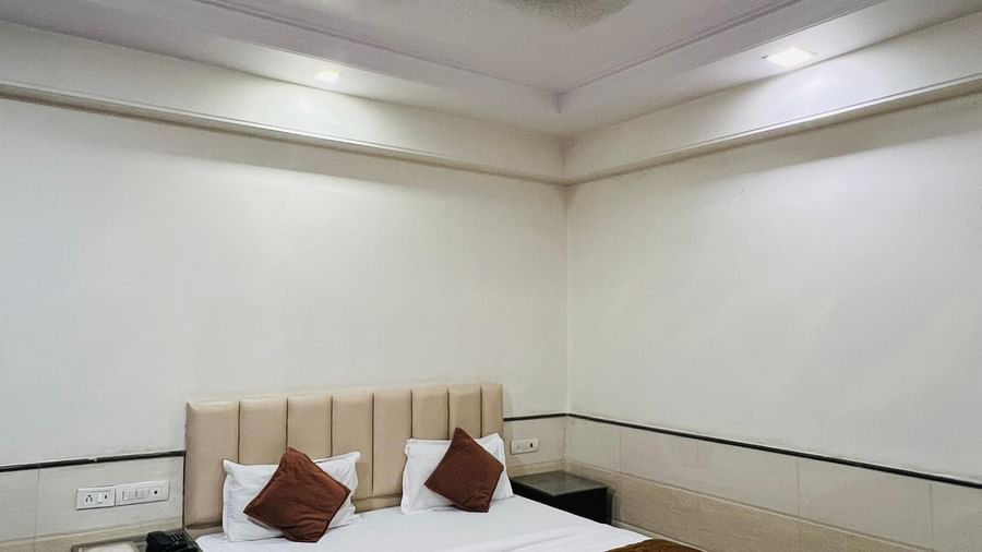 A spacious hotel suite with a sofa seating area, a private entrance, and elegant decor, providing a relaxing retreat. | Suite | Hotel Aadhar