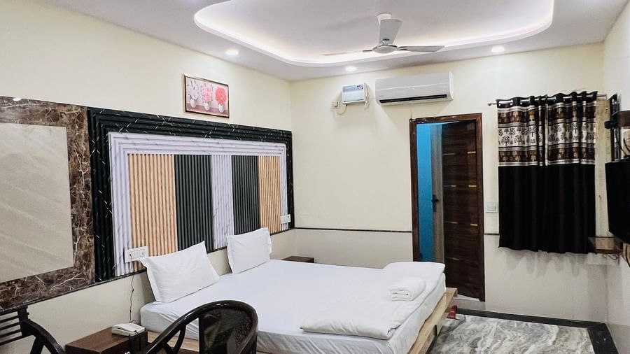 A cozy family room with a bed and a seating area, offering a relaxing and inviting atmosphere. | Family Room | Hotel City Palace DX