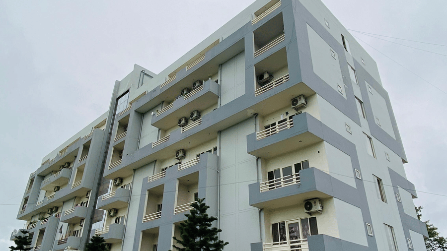 Exterior of a multi-storey Livbox, Rudrapur with greenery and walkway on the foreground.