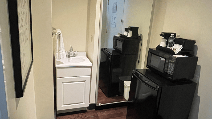 Entryway at Night Hotel Broadway with a small cabinet, mirror, and window providing natural light.