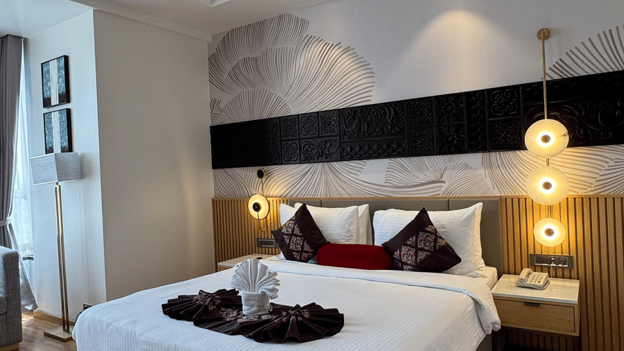 Modern guest room at Lords Inn Somnath featuring a comfortable bed, warm lighting, wooden interiors, seating area and contemporary furnishings for a relaxing stay.
