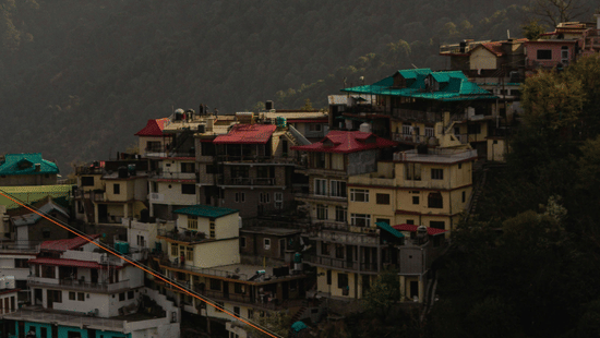 Hillside view of Kasauli with clustered homes overlooking the scenic Shivalik mountains.