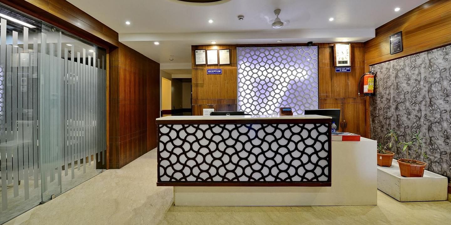 A modern hotel reception area with a stylish counter and warm lighting - Hotel Emerald, Chandigarh