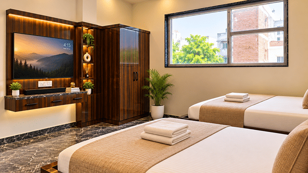 Twin room with a wall-mounted TV, wardrobe and a window view.