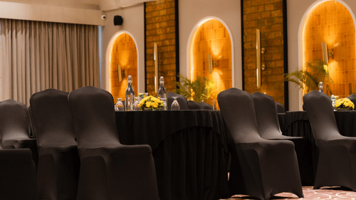 Ballroom with elegantly arranged chairs, complemented by floral carpets that adds a touch of luxury