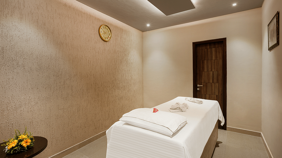  An image of a spa, with a bed in gentle light from the ceiling - The Manor, Bareilly