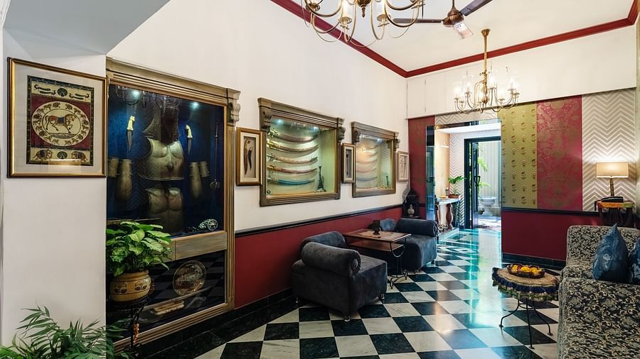 Lobby area at Panna Vilas Palace features mirrors and photo frames on the walls, with a chandelier providing inviting lighting | Panna Vilas Udaipur