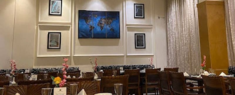 Full view shot of the Gold Plate restaurant with several photo frames wall mounted behind the dining tablesCorner view shot of the dining area of the Gold Plate restaurant with central air-conditioning and a small cabinet in the corner of the restaurant - 