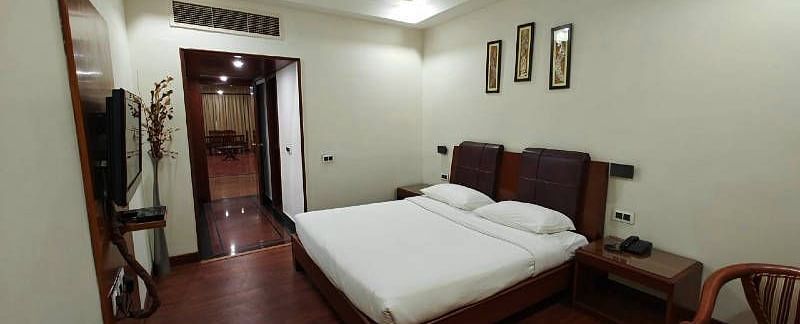 The bedroom of the Suite featuring a plush double bed with minimalist interiors - Hotel Gold, Panipat