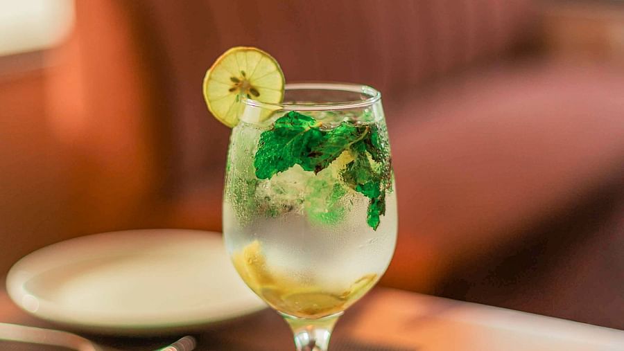 A glass of beverage with mint and lime served on the table at The Bridge - Clarks Inn Suites Jaipur
