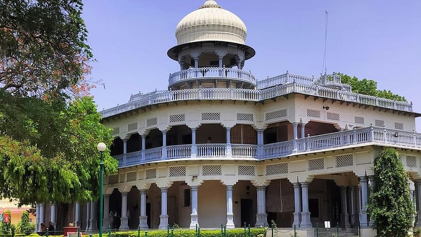 An overview of Anand Bhavan as seen from a distance with a manicured garden in front of it