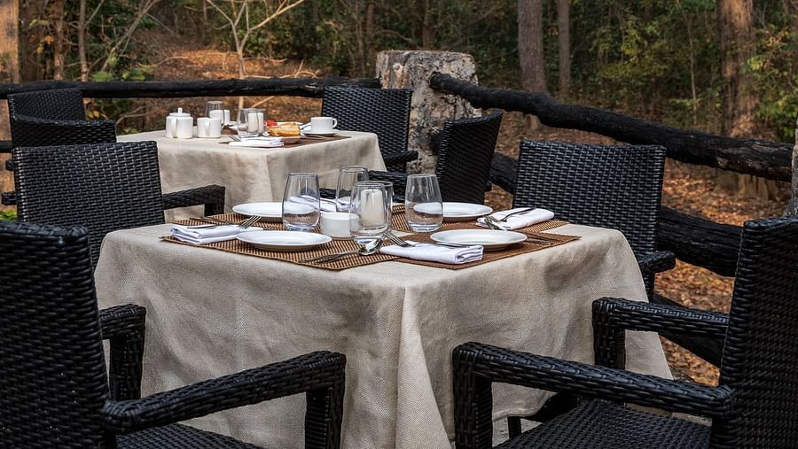A table with two chairs at Machaan dining at Saccharum Safari Lodge, Balaghat