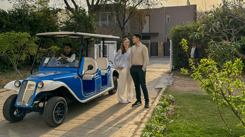 A couple posing for a picture next to an antique car - Karma Lakelands.