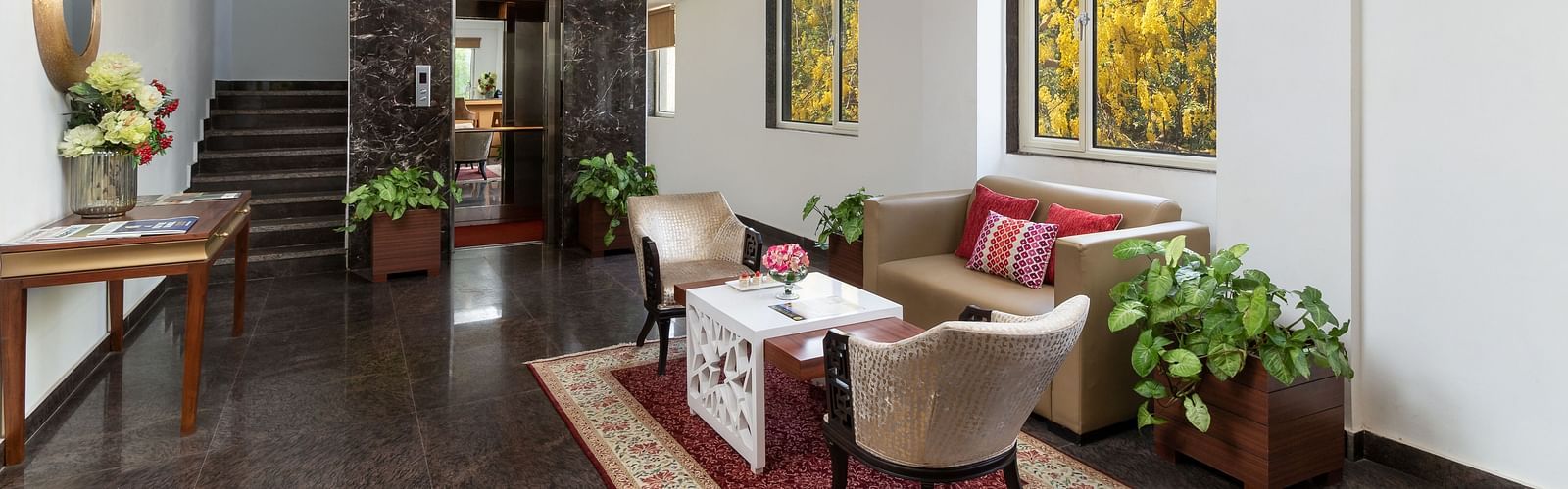 A spacious hotel lobby with comfortable seating, elegant decor, and plenty of natural light | Inde Hotel Cyber City