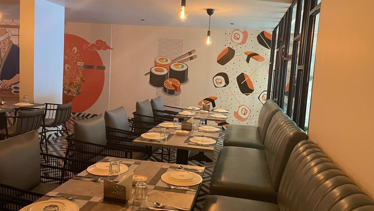View of the dining space with booth seating and a modern ambience at Hotel Kyzen HiTech City – Your Zenly Stay