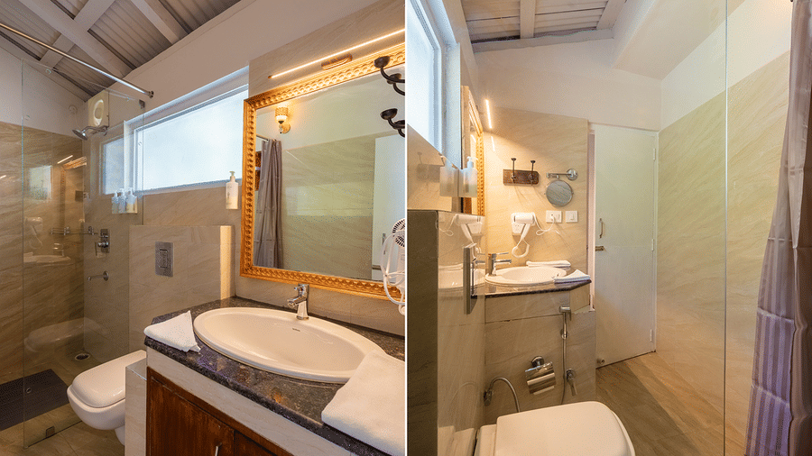 Modern bathroom featuring a white vessel sink, large mirror, and glass shower partition at Maati Resort By The Lake Hill, Jeolikote.