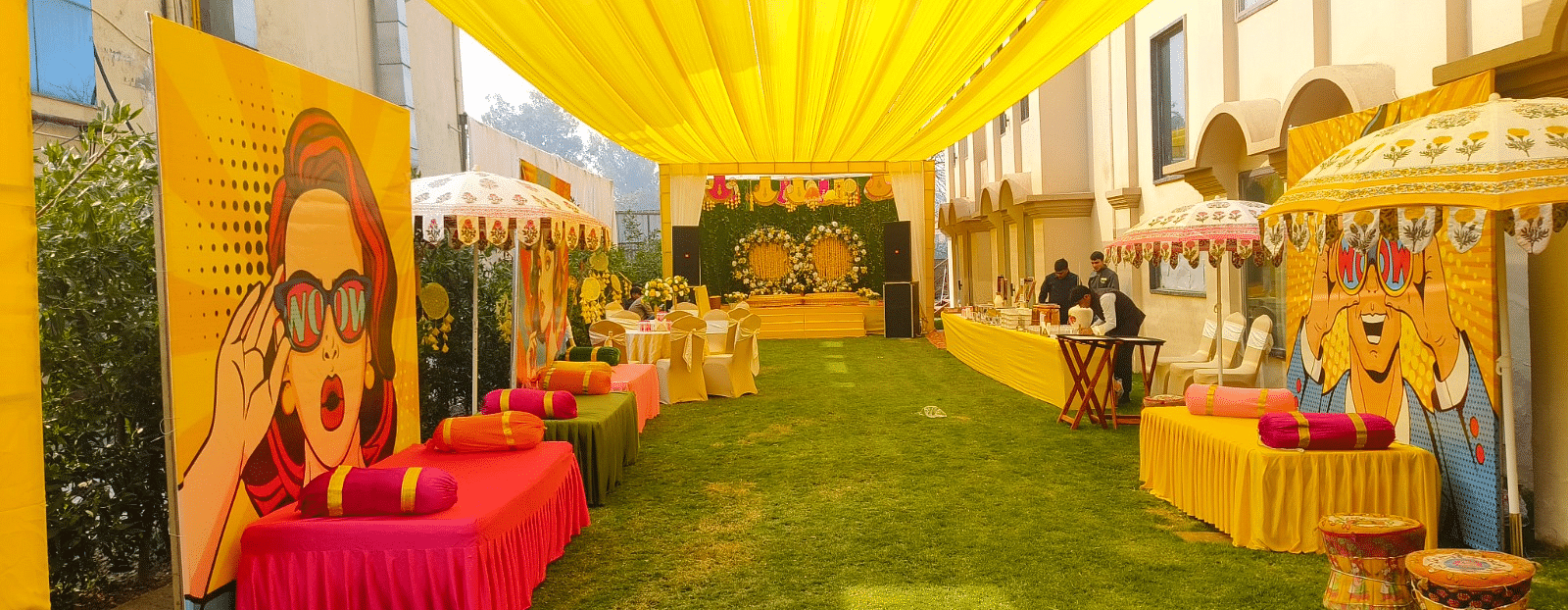 Brij Eternity, Vrindava |  A vibrant, open-air setup with bright yellow drapes and festive décor for pre-wedding rituals.