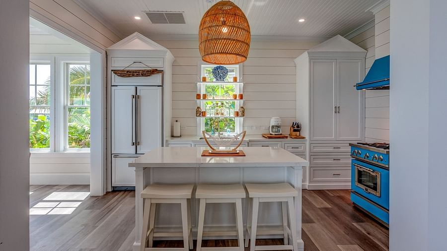 Kitchen and dining area featuring a white island, blue stove, and woven pendant light | Abaco Inn