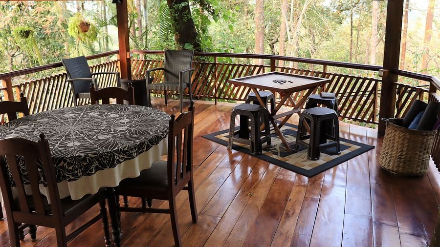 A platform with tables, chairs and carrom board, on a wooden floor.