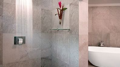 Modern bathroom with a walk-in rain shower, sleek stone tiles, and a freestanding tub, offering a spa-like retreat with luxurious finishes.