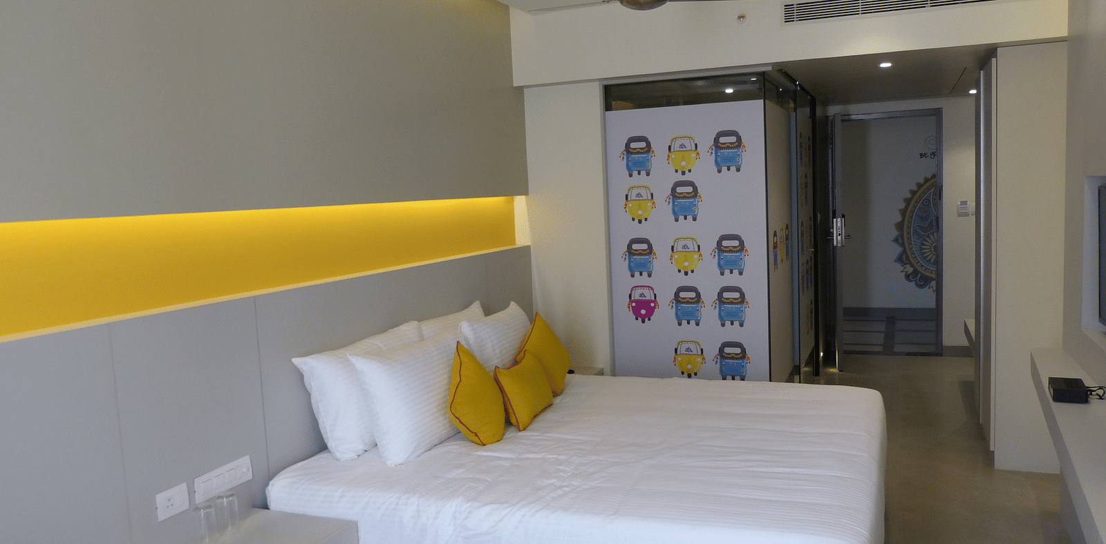 Spacious twin beds with headboards stretch across the wall with door way leading to the  next room