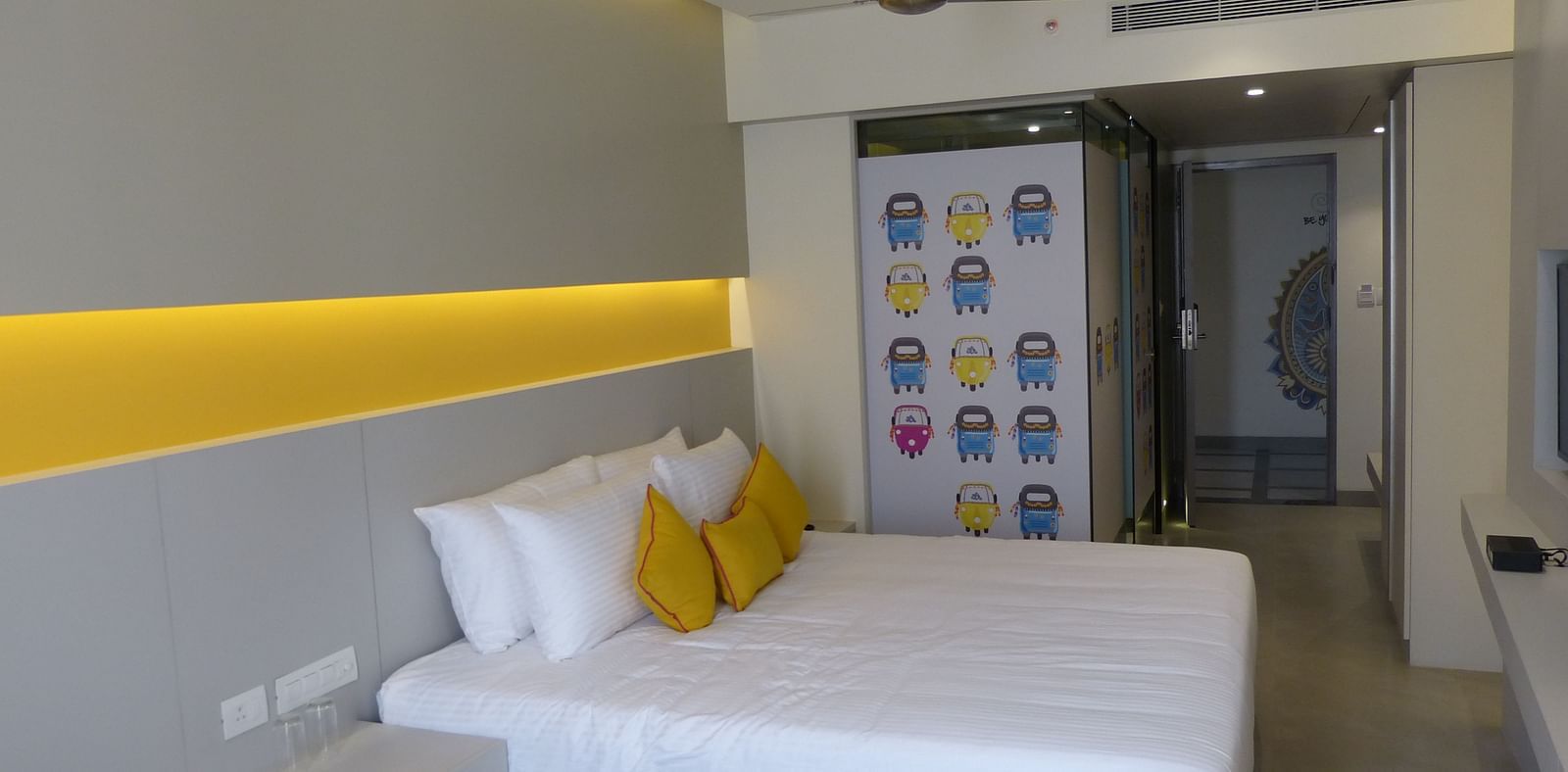 Spacious twin beds with headboards stretch across the wall with door way leading to the  next room