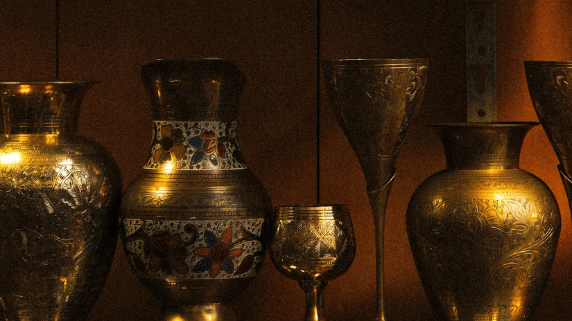 Rows of polished brass vessels and traditional metalware displayed in a glass cabinet