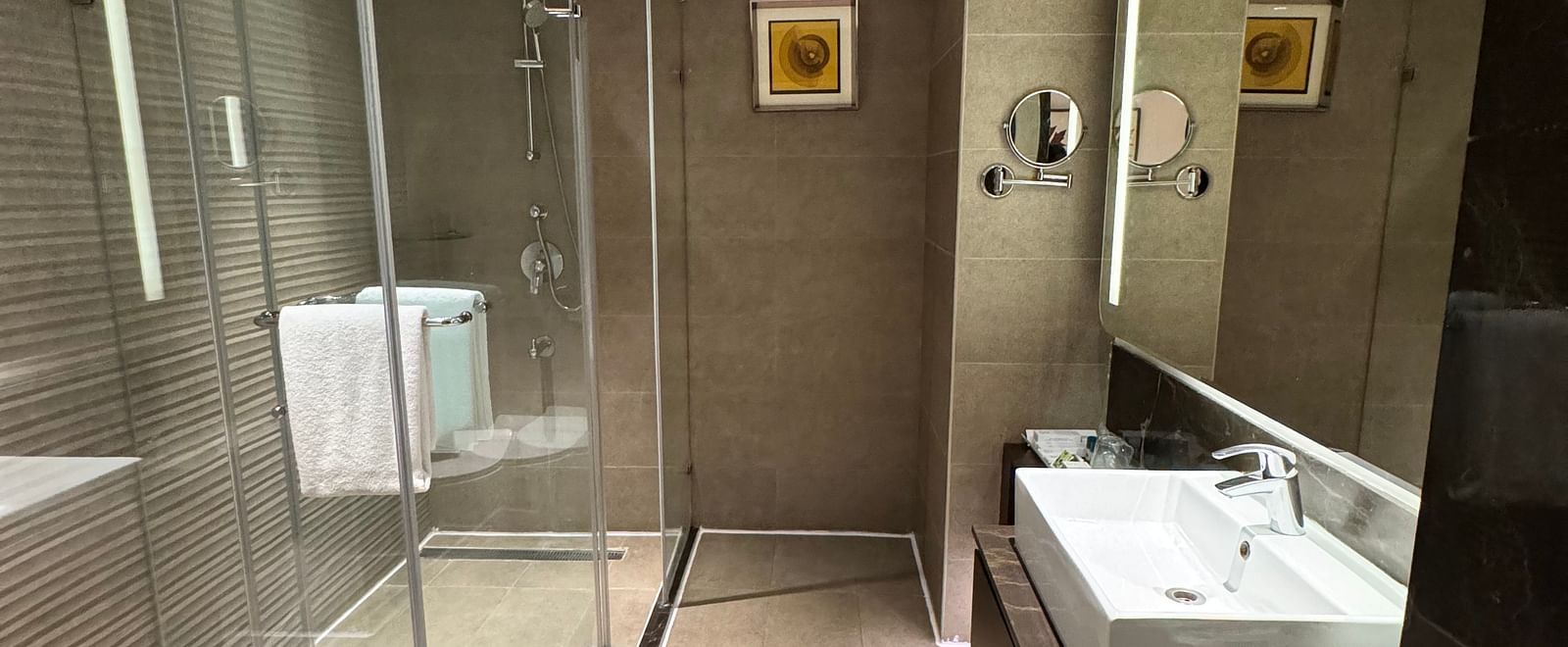 A modern and well-lit bathroom with a shower and sink area at Cenneys Gateway.
